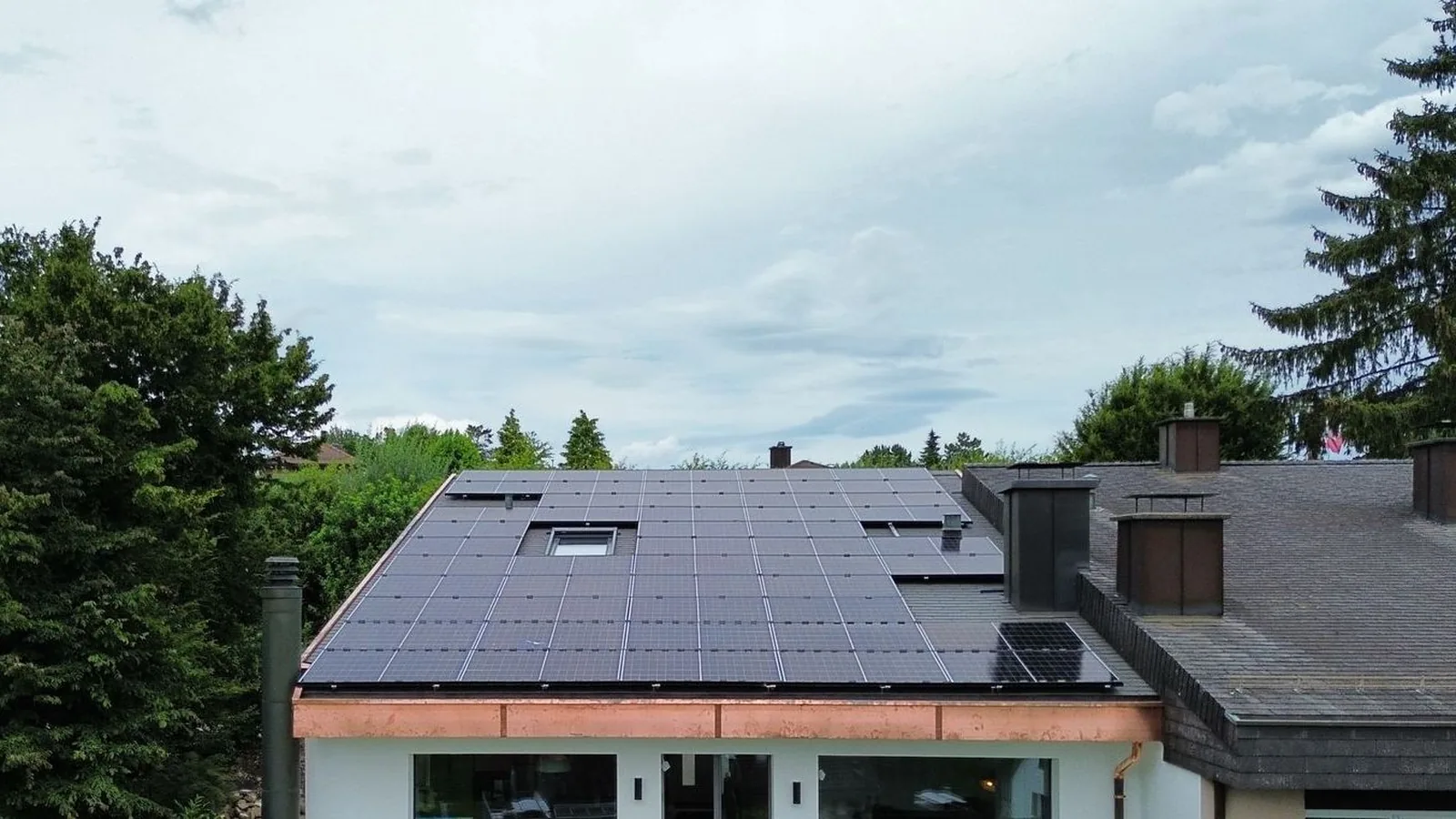 Einfamilienhaus in Wallisellen, das Schindeldach ist mit Solarmodulen belegt