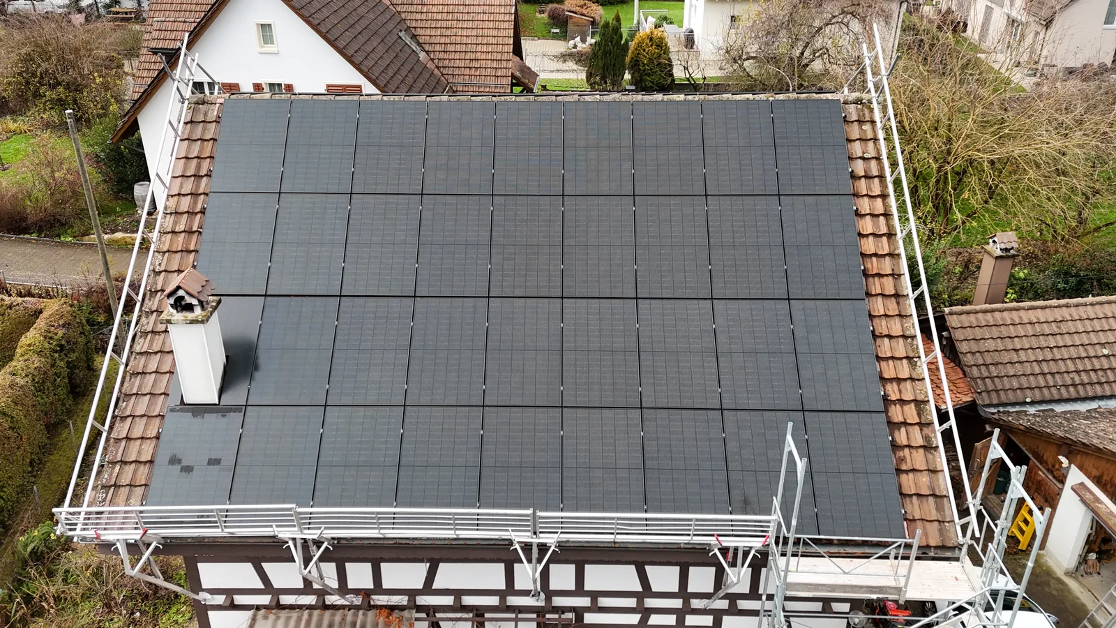 Älteres Fachwerkhaus in Schleinikon, das Ziegeldach ist vollflächig in Ost-West-Ausrichtung mit Solarmodulen belegt